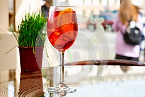 Traditional Spritz aperitif in a bar in Italy, glass of cocktail Aperol Spritz on table terrace of restaurant