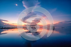 Traditional square fishnet equipment at sunrise in Pakpra Canal, Phatthalung, Thailand