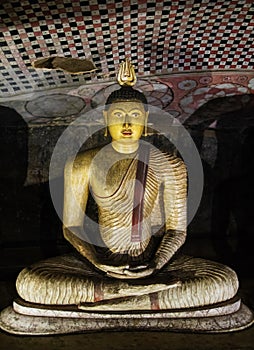 Traditional Sri Lankan image of the Buddha who sits in meditation, in the Lotus position in cave temple