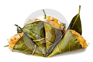 Traditional steamed ripe palmyra palm fruit cake wrapped with jackfruit leaves and sprinkled with coconut pieces.