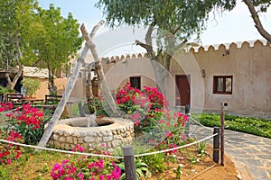 Traditional stone house and well in the front garden at the Heritage village, Abu Dhabi, United Arab Emirates photo