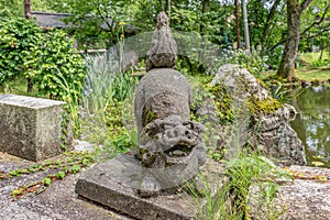 Traditional stone sculpture of komainu, or lion-dog, at the Hanibe caves complex, Komatsu, Ishikawa Prefecture, Japan.