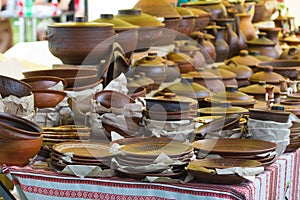 Traditional style modern handmade ceramic clay plates, pots and pans on sale at outdoor summer ethno festival fair