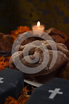 Traditional sugary dead bread celebrating dia de muertos and using cempasuchienlt flowers, two coffins all on one altar photo