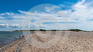 Traditional summer landscape with sandy and pebbly promontory, blue sea and sky, Harilaid Nature Reserve, Estonia, Baltic Sea