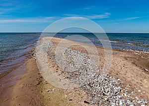 Traditional summer landscape with sandy and pebbly promontory, blue sea and sky, Harilaid Nature Reserve, Estonia, Baltic Sea