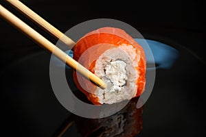 Traditional sushi roll with salmon on a black background. Japanese food