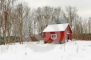 Traditional Swedish red wooden house in snow