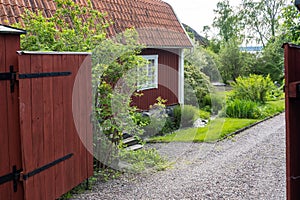 Traditional Swedish wooden house. Countryside village in Scandinavia. Red typical cottage rural house. Entrance open. Old wooden