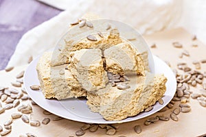 Traditional sweet turkish delight halva pieces with sunflower seeds on light background.