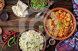 Traditional tajine dishes, couscous and fresh salad on rustic wooden table. Tagine lamb meat and pumpkin. Top view. Flat lay