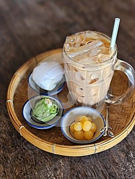 Traditional Thai iced tea serving with small portion of Thai traditional dessert