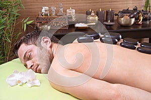Traditional thai massage - man getting hotstone treatment