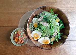 Traditional Thai spicy shrimp paste chili sauce and variety fresh green vegetable salad with boil egg bowl