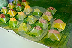 Traditional Thai sticky rice dessert with variety toppings wrapped in banana leaf.