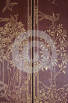 Traditional Thai style art gold painting pattern on the door in Temple Bangkok, Thailand