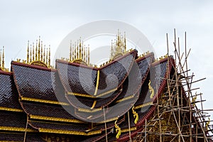 The traditional Thai style church with the bamboo scaffolding to paint the gable