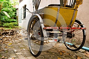 Traditional Thai transport â€“ old yellow trishaw on a street.