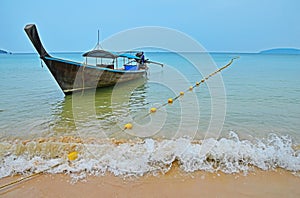 Traditional Thailand old long tail boat in transparent water