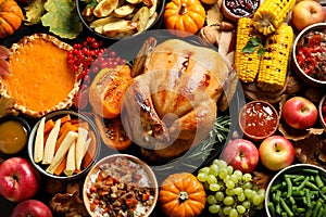 Traditional Thanksgiving day feast with delicious cooked turkey and other seasonal dishes as background, top view