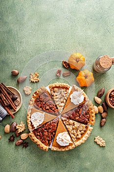 Traditional Thanksgiving pies cut into slices with pumpkin, pecan and crumble