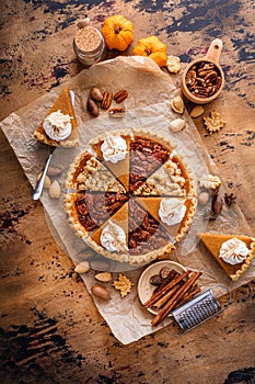 Traditional Thanksgiving pies cut into slices with pumpkin, pecan and crumble