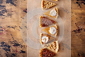Traditional Thanksgiving pies cut into slices with pumpkin, pecan and crumble