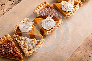 Traditional Thanksgiving pies cut into slices with pumpkin, pecan and crumble