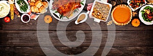 Traditional Thanksgiving turkey dinner. Above view top border on a dark wood banner background.