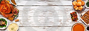 Traditional Thanksgiving turkey dinner. Overhead view double border on a rustic white wood banner background.