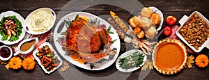 Traditional Thanksgiving turkey dinner. Top view table scene on a dark wood banner background.