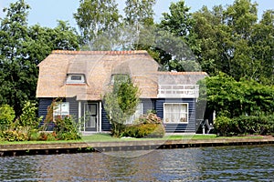Traditional thatched roof Dutch house water lake , Giethoorn, Netherlands