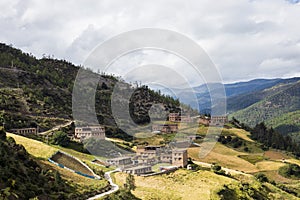 Traditional Tibetan countryside with fields and mountains around Daocheng