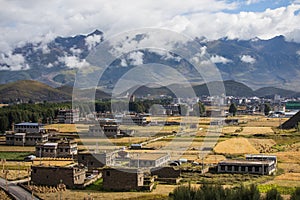 Traditional Tibetan countryside with fields and mountains around Daocheng