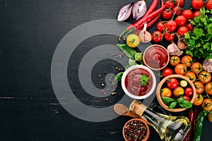 Traditional tomato ketchup sauce. Cherry tomatoes, spices, chili peppers, olive oil, parsley. Top view.