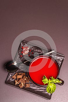 Traditional tomato soup in a cup. Basil, croutons, spices, cutlery