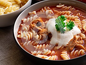 Traditional tomato soup with noodles, whitened with cream photo