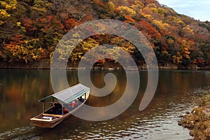 Traditional touris travel boat on the river in Kyoto city with autumn season background photo