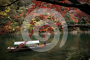 Traditional touris travel boat on the river in Kyoto city with autumn season background photo