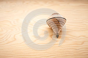 Traditional toy called spinning top made of wood with metal end