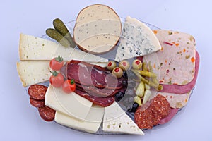 Traditional Turkish breakfast platter on the grey wooden table, top view: pogaca pasties, vegetables, cheeses, olives and halal tu