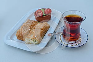Traditional Turkish breakfast, tea, water pastry and tomato, cucumber