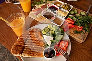 Traditional turkish breakfast on a wooden plate. Cheese toast with freshly squeezed orange juice