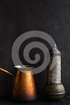 Traditional Turkish coffee and concept. Copper coffee pot. Cezve, vintage coffee grinder on a dark background