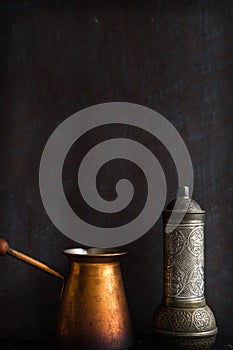 Traditional Turkish coffee and concept. Copper coffee pot. Cezve, vintage coffee grinder on a dark background