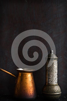 Traditional Turkish coffee and concept. Copper coffee pot. Cezve, vintage coffee grinder on a dark background