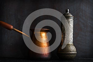 Traditional Turkish coffee and concept. Copper coffee pot. Cezve, vintage coffee grinder on a dark background