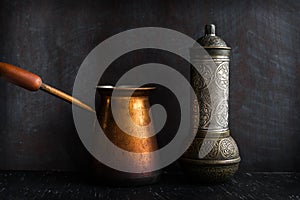 Traditional Turkish coffee and concept. Copper coffee pot. Cezve, vintage coffee grinder on a dark background