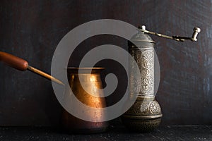 Traditional Turkish coffee and concept. Copper coffee pot. Cezve, vintage coffee grinder on a dark background