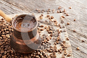Traditional turkish coffee in copper coffee pot on coffee beans